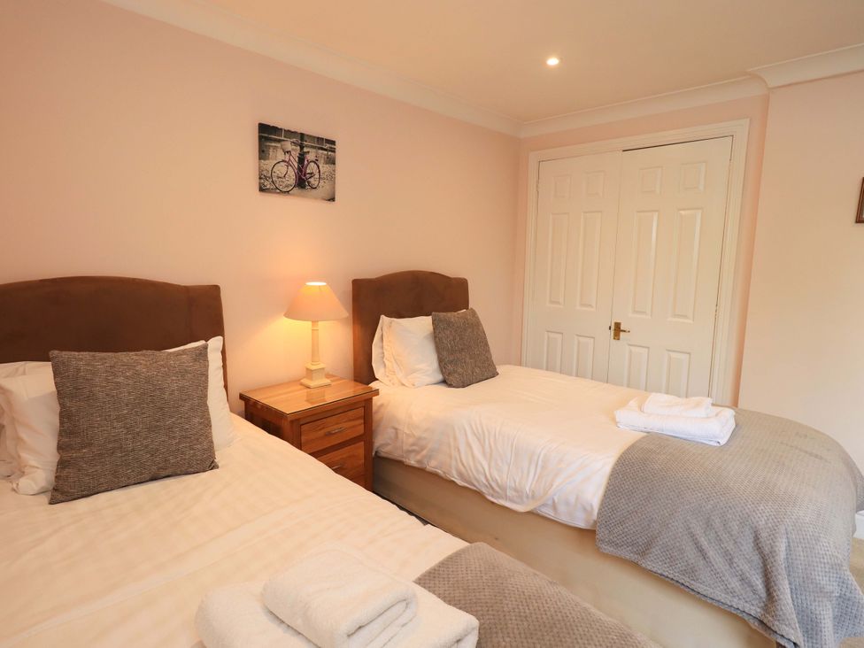 A bedroom with two beds and a lamp at Gillybeck in Ambleside