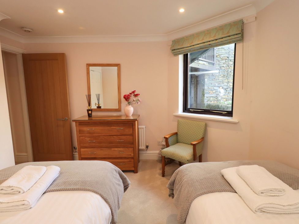 A bedroom with two beds and a dresser at Gillybeck in Ambleside