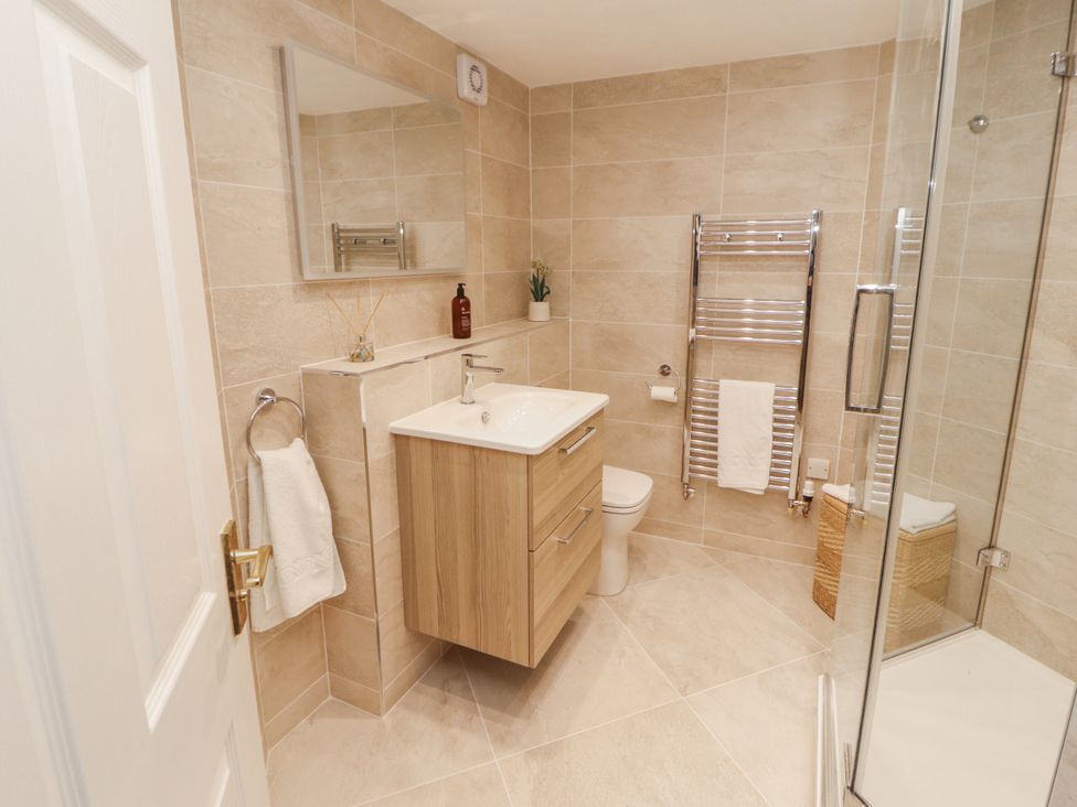A bathroom with a sink, toilet, and shower at Chapelside Cottage in Ambleside