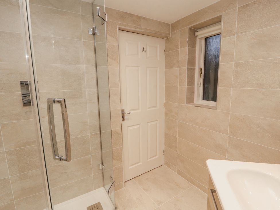 A bathroom with a shower and sink at Chapelside Cottage in Ambleside