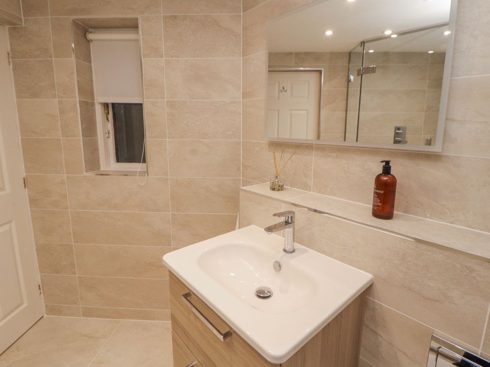 A bathroom with a sink and mirror at Chapelside Cottage in Ambleside