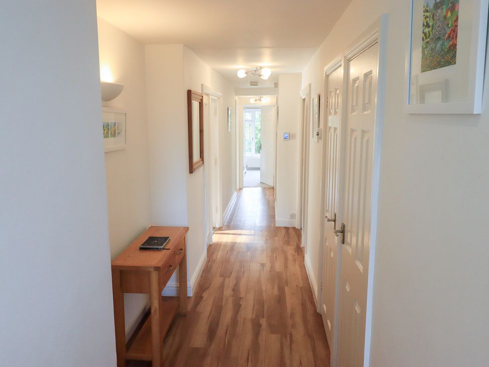 A hallway with wood flooring and a console table at Mardale in Ambleside