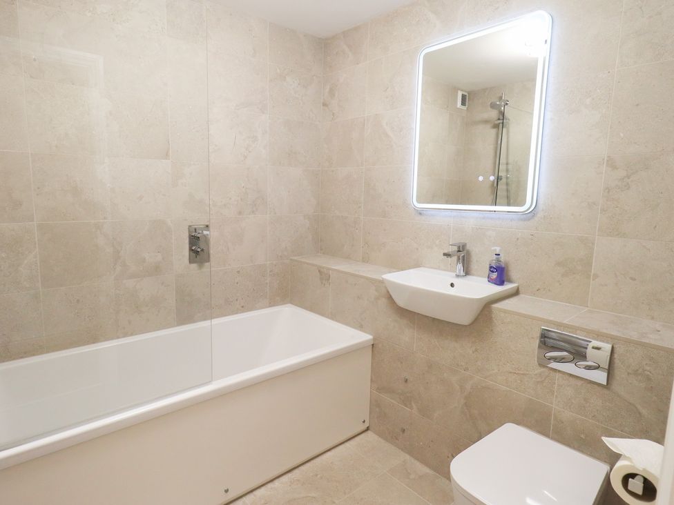 A bathroom with a bathtub, sink, and toilet at Mardale in Ambleside