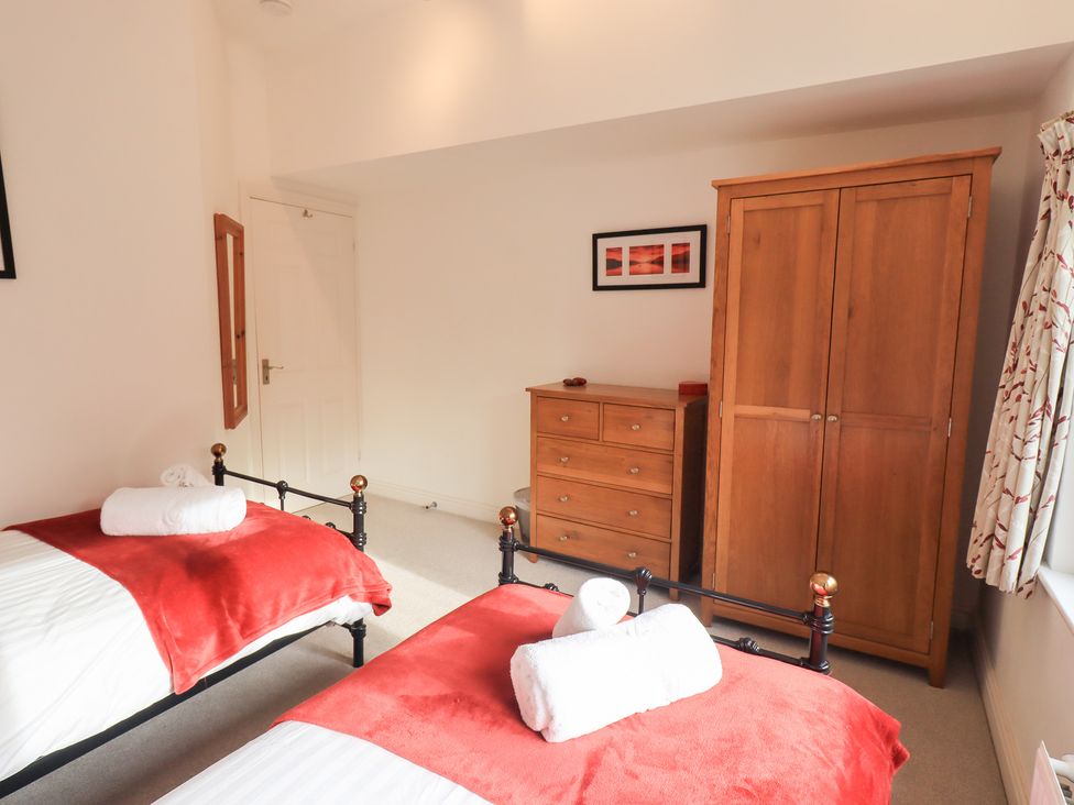 A bedroom with two beds and a wardrobe at Mardale in Ambleside