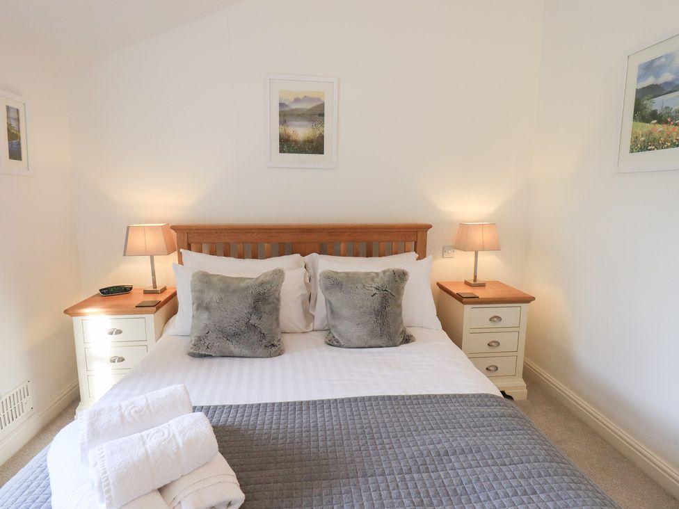 A bedroom with a bed and nightstands at Mardale in Ambleside