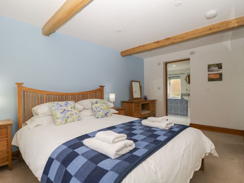 A bedroom with a double bed and a dresser at Cygnet Cottage in Thornthwaite