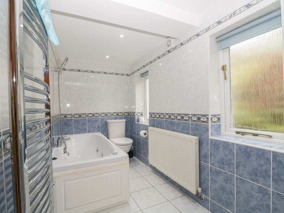 A bathroom with a bathtub and toilet at Cygnet Cottage Thornthwaite