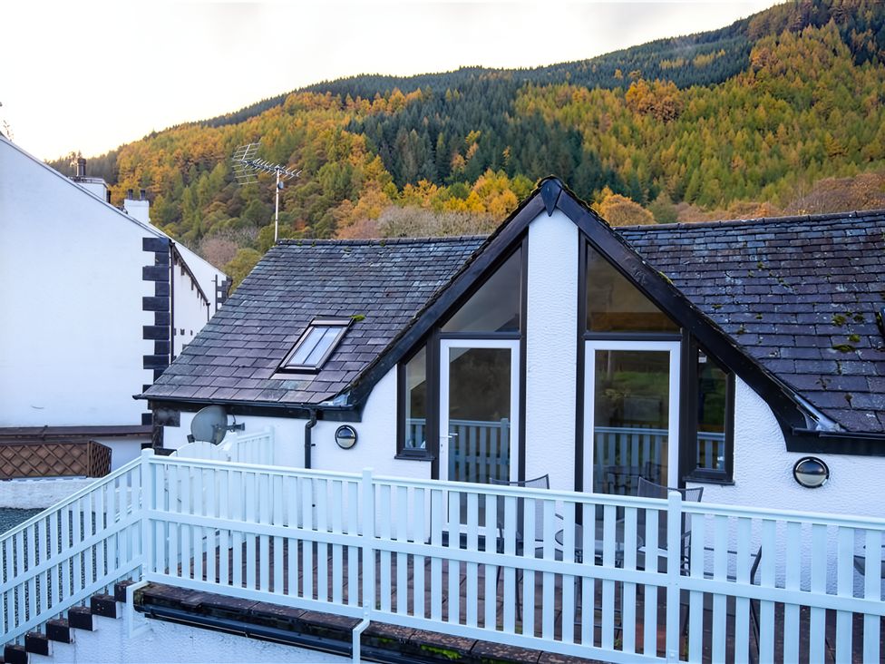 A house with a balcony and windows overlooking mountains at Cygnet Cottage Thornthwaite