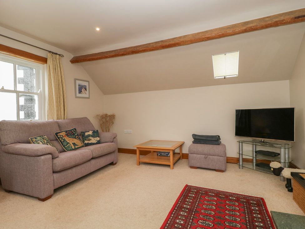 A living room with a sofa and coffee table at Cygnet Cottage in Thornthwaite