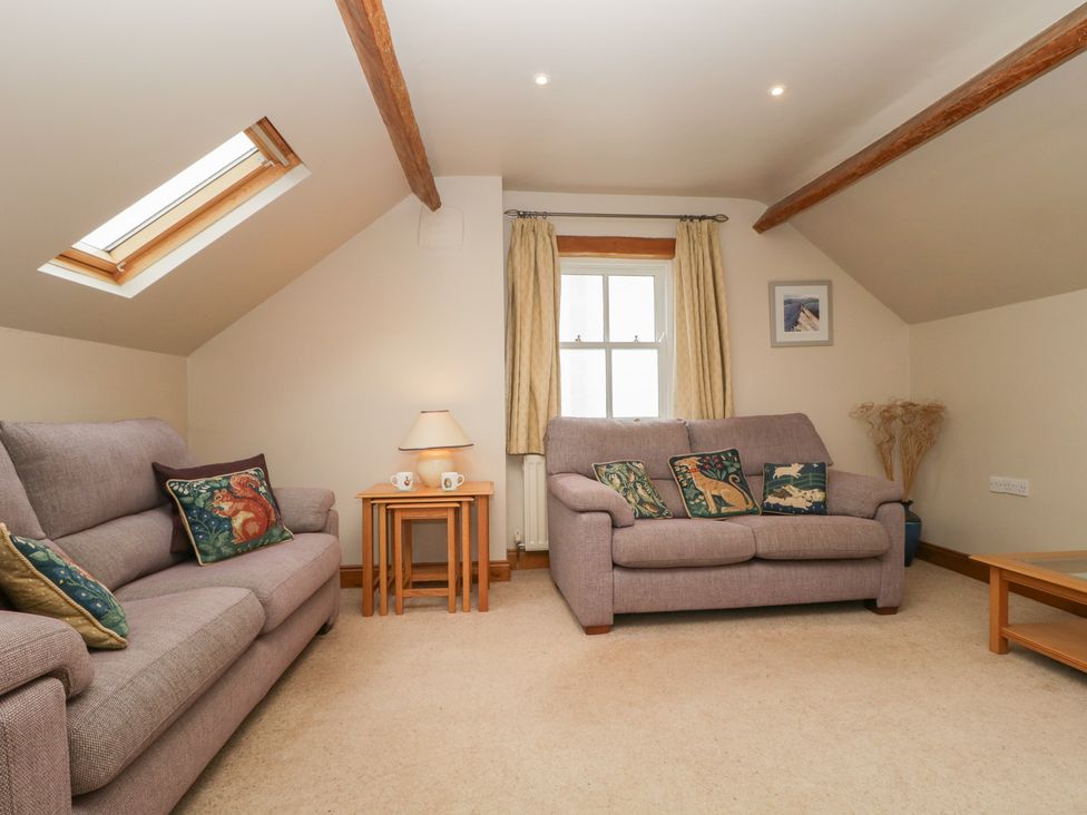 A living room with sofas and a coffee table at Cygnet Cottage in Thornthwaite