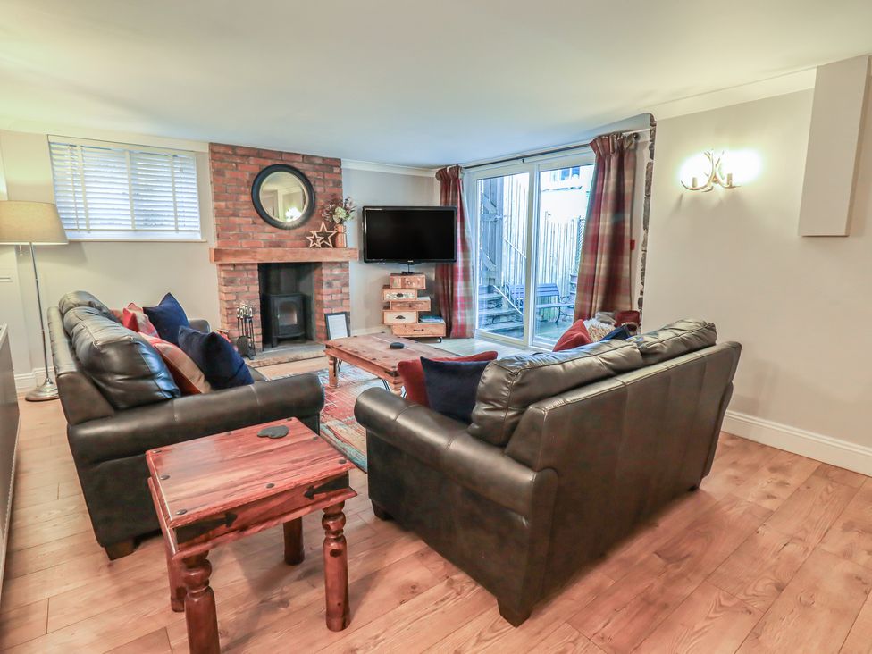 A living room with a sofa and television at Chapel Hill Cottage in Ambleside