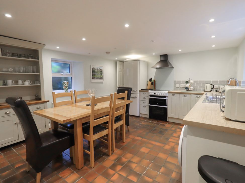 A kitchen with a dining table and appliances at Chapel Hill Cottage in Ambleside