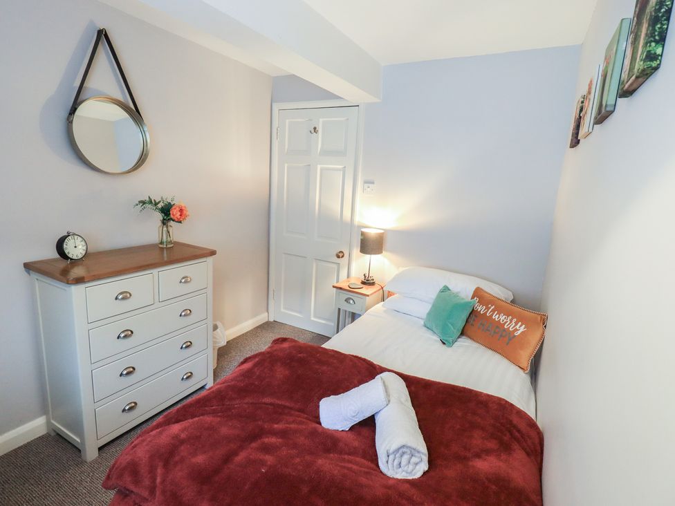 A bedroom with a bed and a dressing table at Chapel Hill Cottage in Ambleside