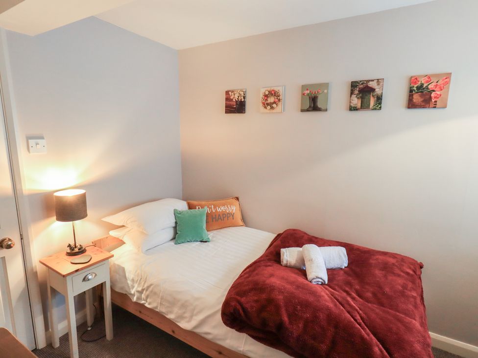 A bedroom with a bed and wall art at Chapel Hill Cottage in Ambleside