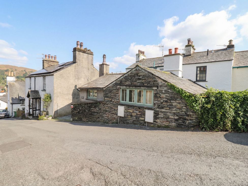A view of stone houses with chimneys on a road at Chapel Hill Cottage in Ambleside