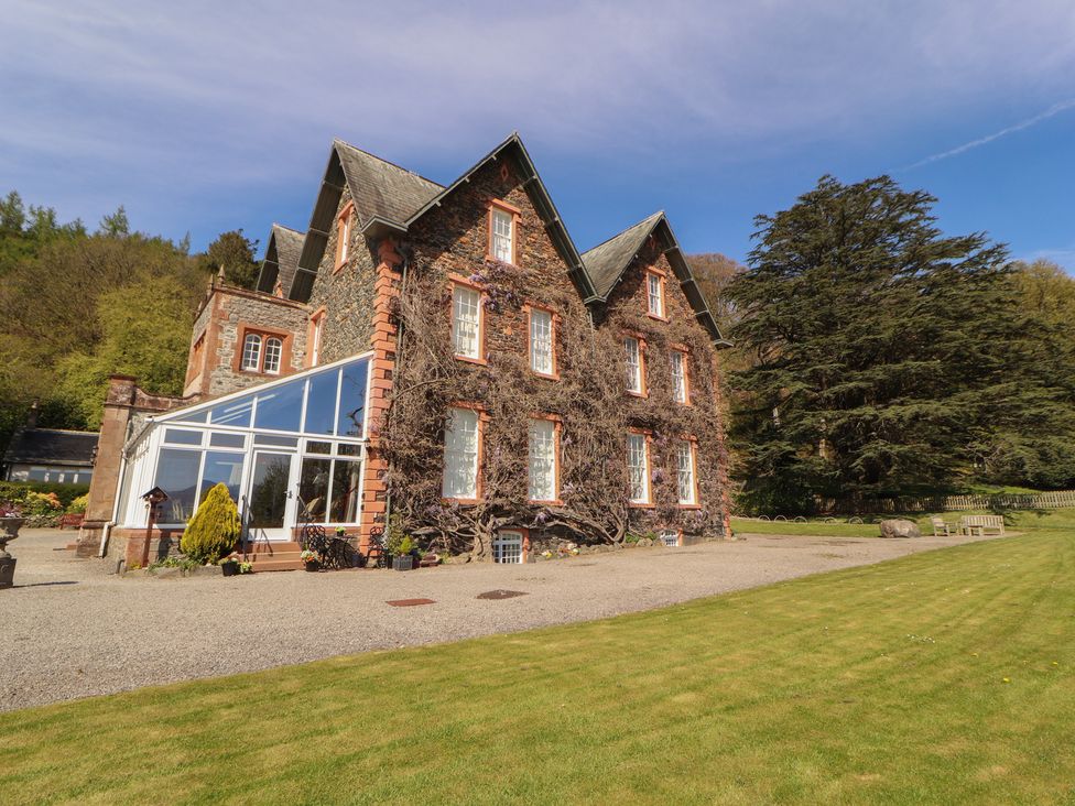 A house exterior with a conservatory and garden at South View in Keswick