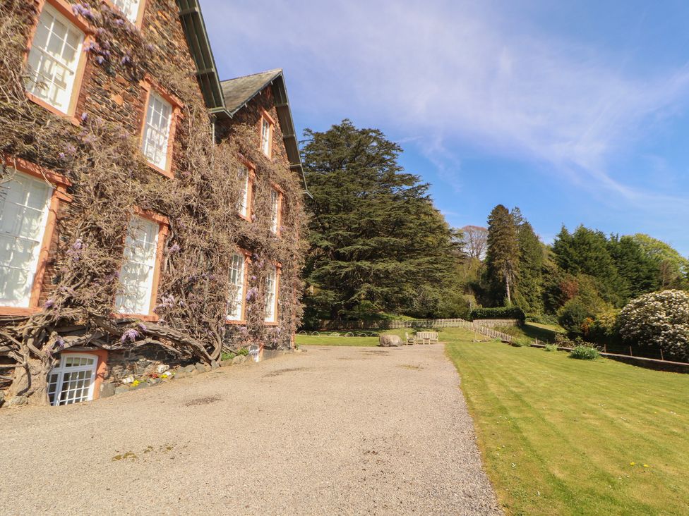 A garden area with a house and trees at South View in Keswick