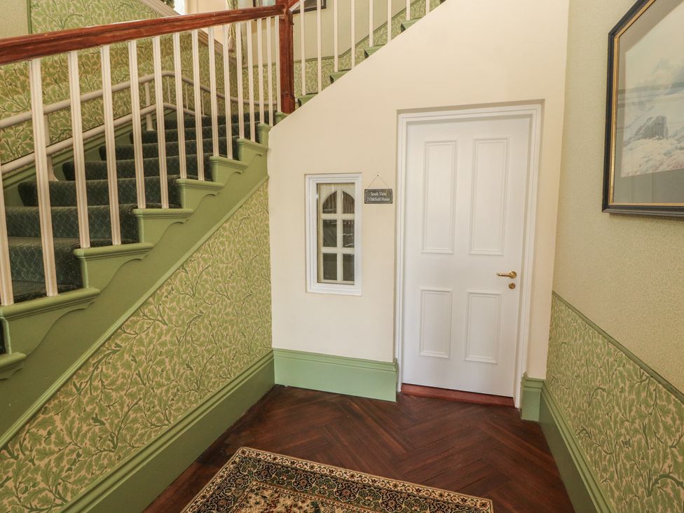 A hallway with stairs and door at South View in Keswick