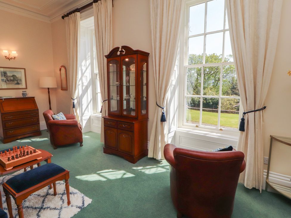 A living room with a glass cabinet and chess set at South View in Keswick