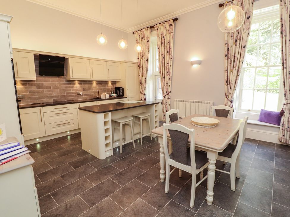 A kitchen with an island and dining table at South View in Keswick