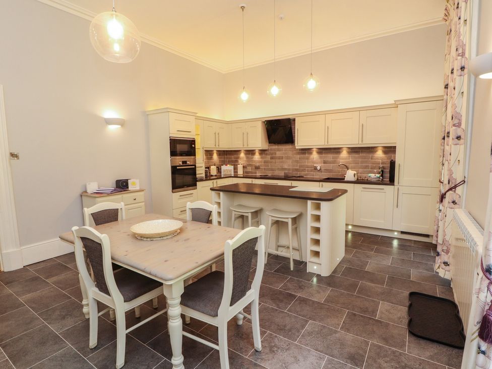 A kitchen with a dining table and kitchen cabinets at South View in Keswick