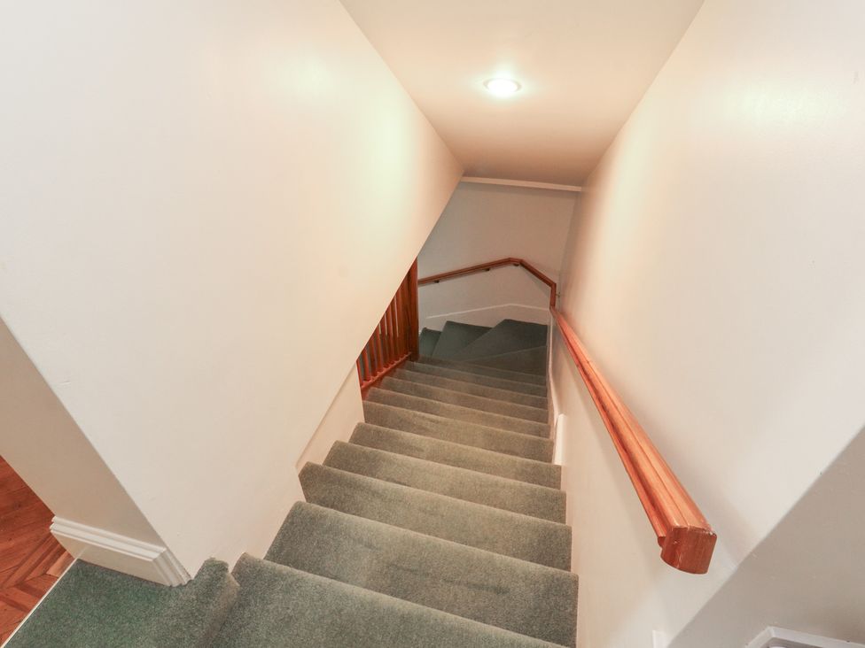 A staircase with carpet and handrail at South View in Keswick