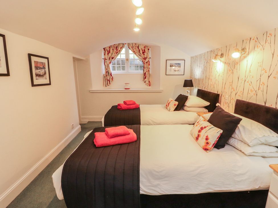 A bedroom with two beds and a window at South View in Keswick