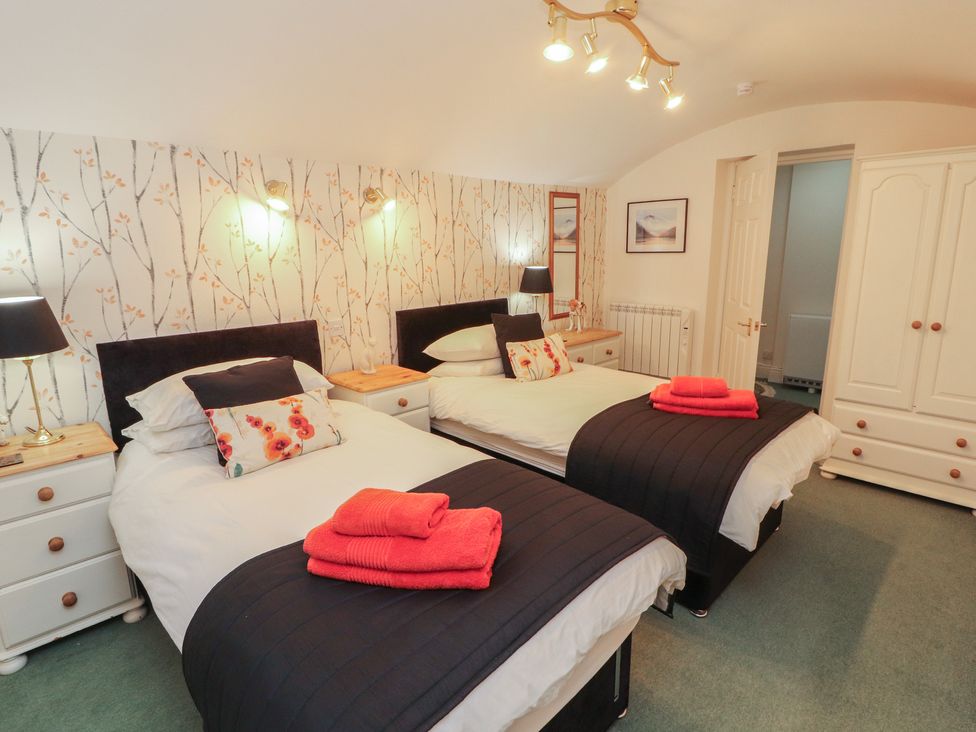 A bedroom with two beds and nightstands at South View in Keswick