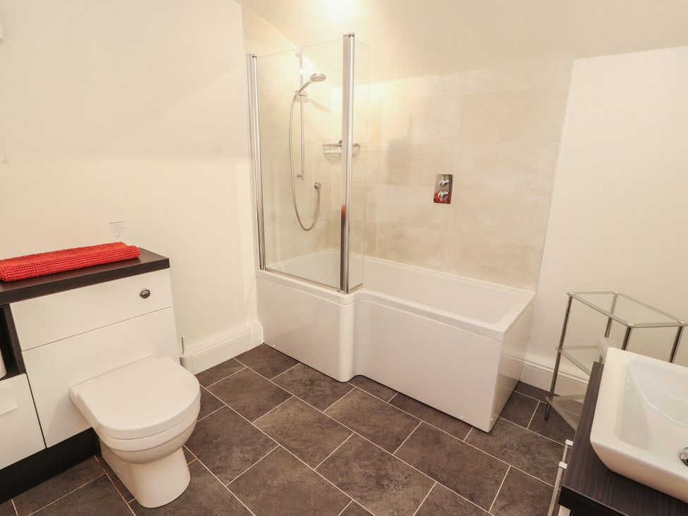 A bathroom with a bathtub, shower, toilet and sink at South View in Keswick