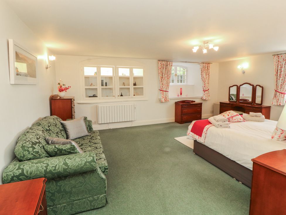 A bedroom with a bed and sofa at South View in Keswick