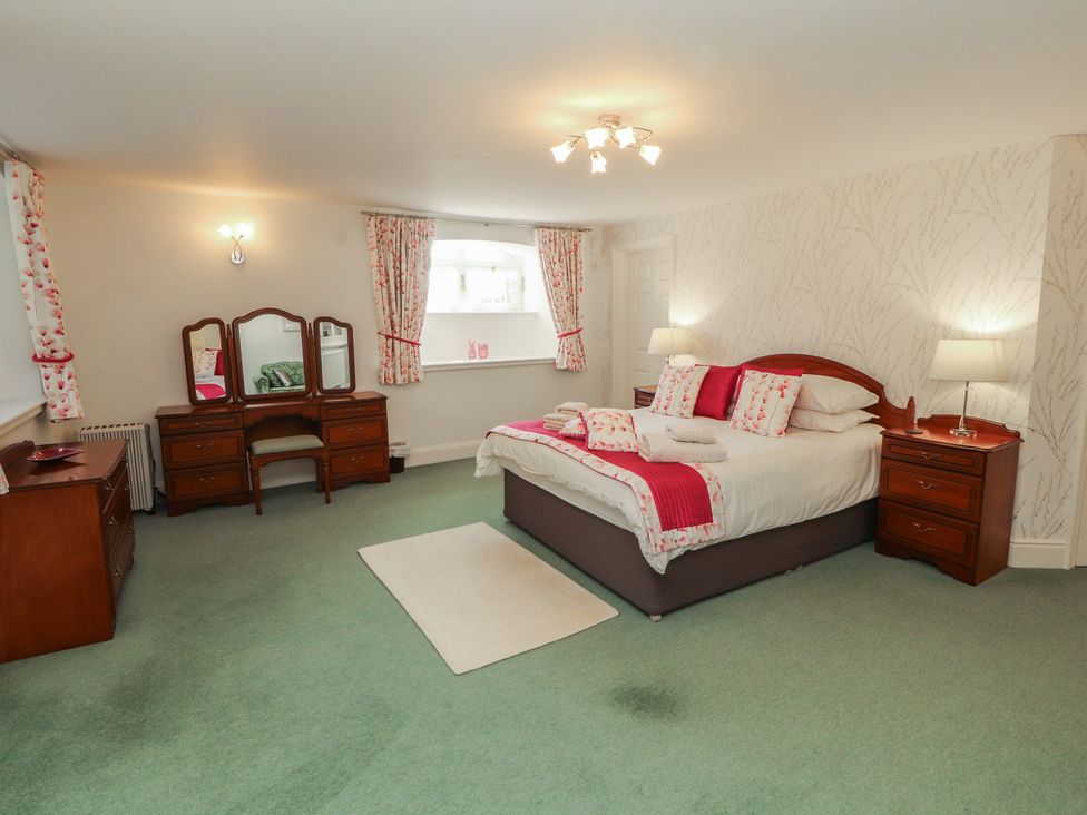 A bedroom with a bed and dressing table at South View in Keswick