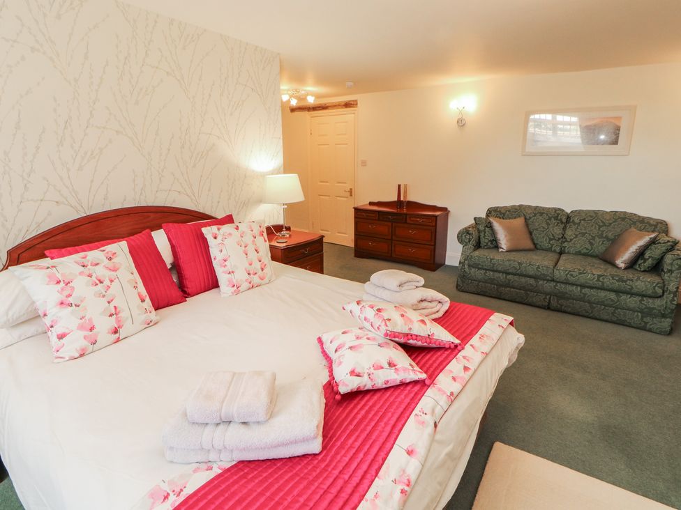 A bedroom with a bed and sofa at South View in Keswick