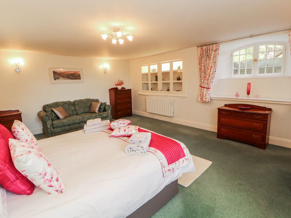 A bedroom with a bed and sofa at South View in Keswick