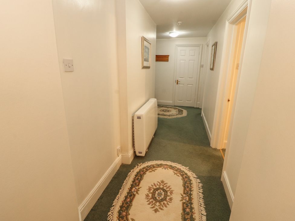 A hallway with a radiator and framed pictures at South View in Keswick