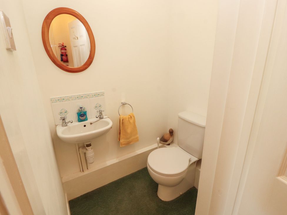 A bathroom with a sink, toilet, and mirror at South View in Keswick