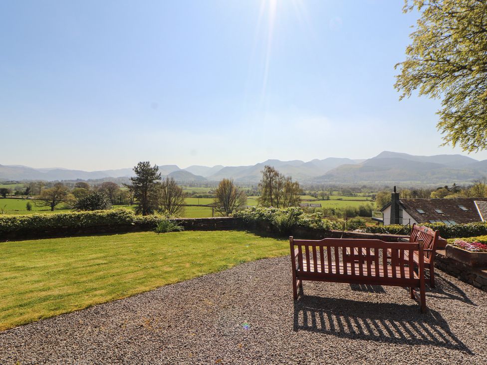A garden view with a bench and mountains in the background at South View in Keswick