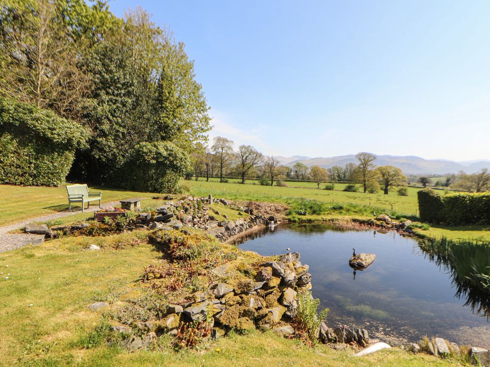 A garden with a pond and bench at South View in Keswick