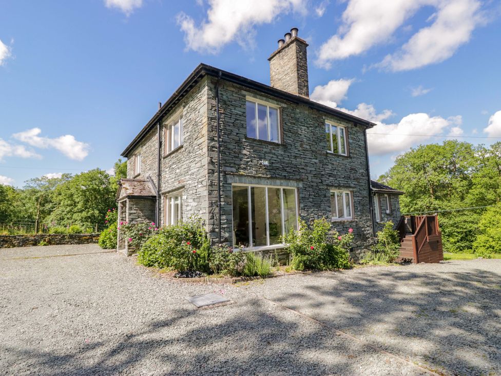 A house with stone exterior and large windows at Elterwater Lodge in Elterwater