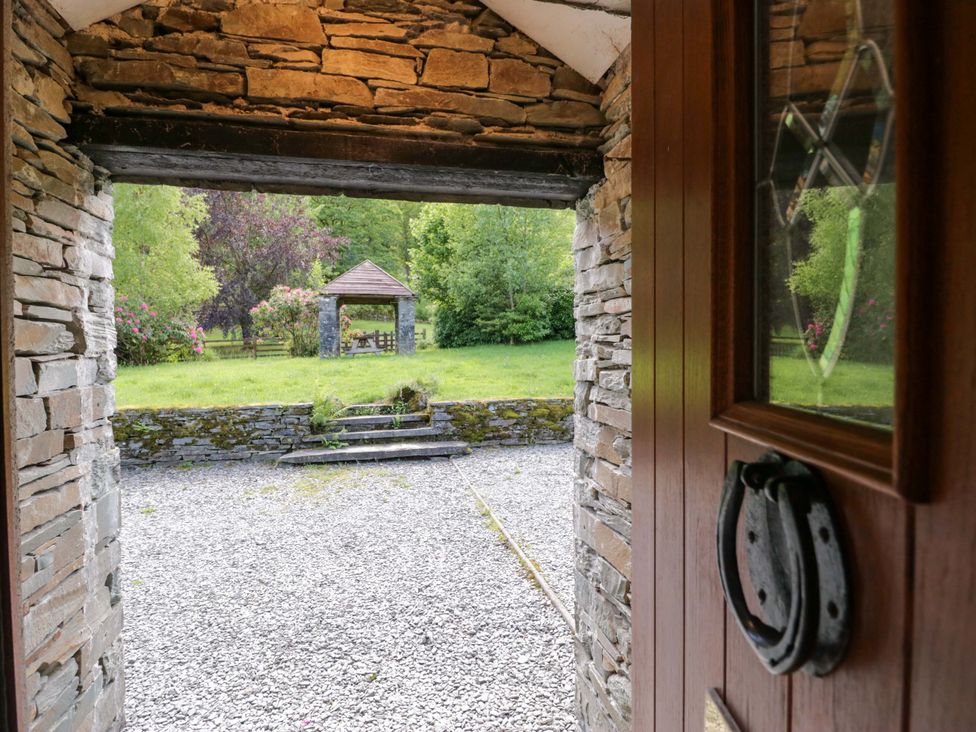 A view from a doorway showing a gazebo and grass area at Elterwater Lodge in Elterwater