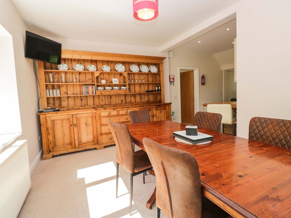 A dining room with a wooden dining table and chairs at Elterwater Lodge in Elterwater