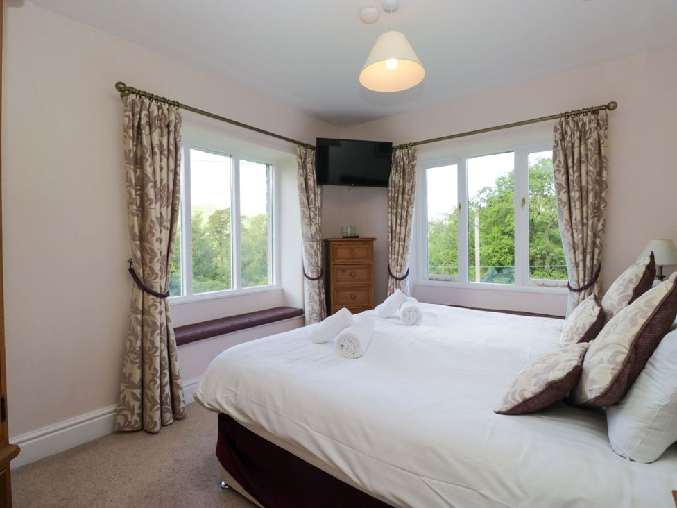 A bedroom with a bed and window view at Elterwater Lodge Elterwater