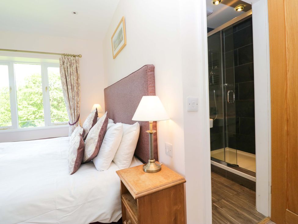 A bedroom with a bed and shower enclosure at Elterwater Lodge Elterwater