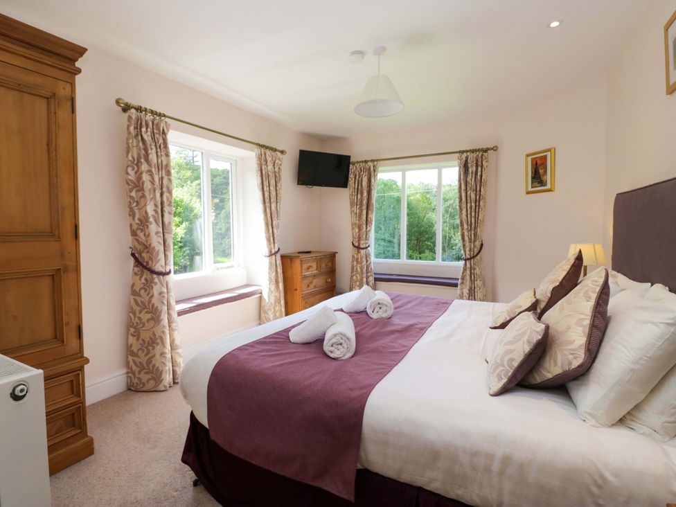A bedroom with a bed and window at Elterwater Lodge in Elterwater