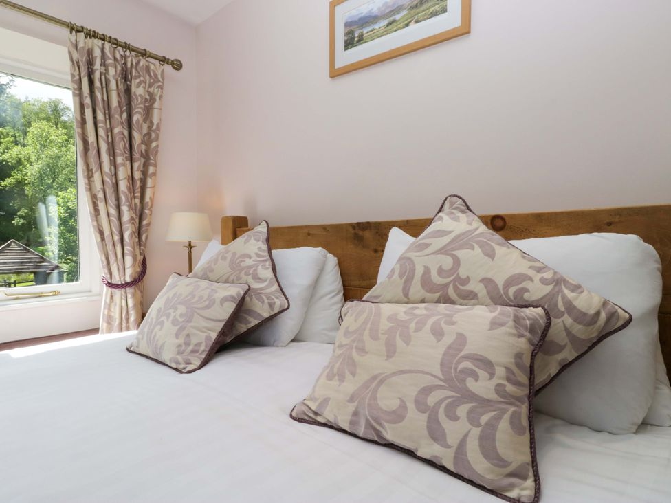A bedroom with a bed and cushions at Elterwater Lodge in Elterwater