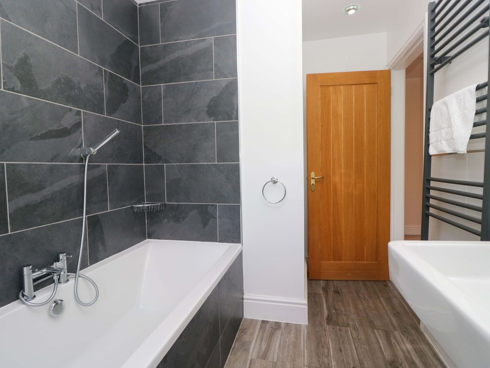 A bathroom with a bathtub and sink at Elterwater Lodge in Elterwater
