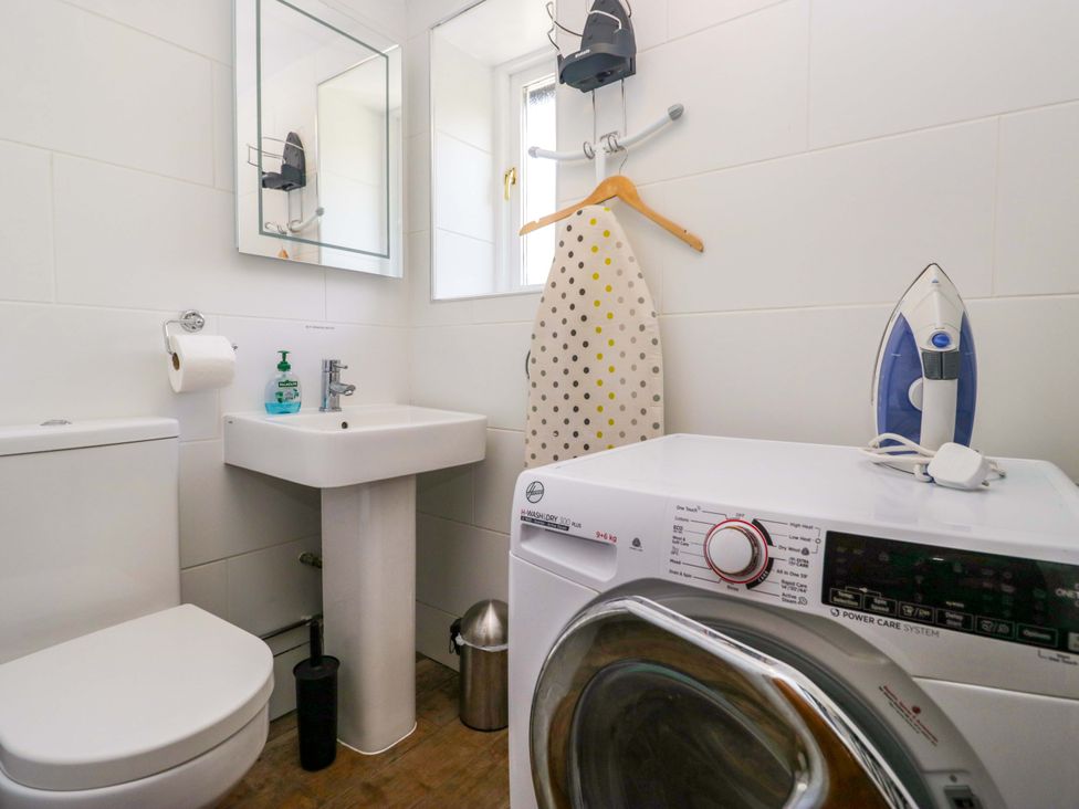 A bathroom featuring a sink, toilet, and washing machine at Elterwater Lodge in Elterwater
