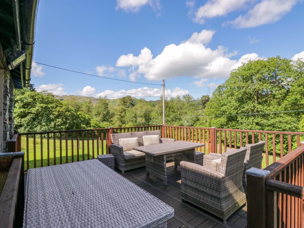 An outdoor deck with seating and a table at Elterwater Lodge in Elterwater