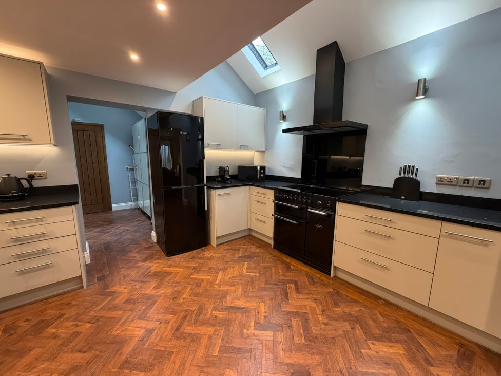 A kitchen with appliances and cabinets at Dancing Beck Cottage in Millbeck