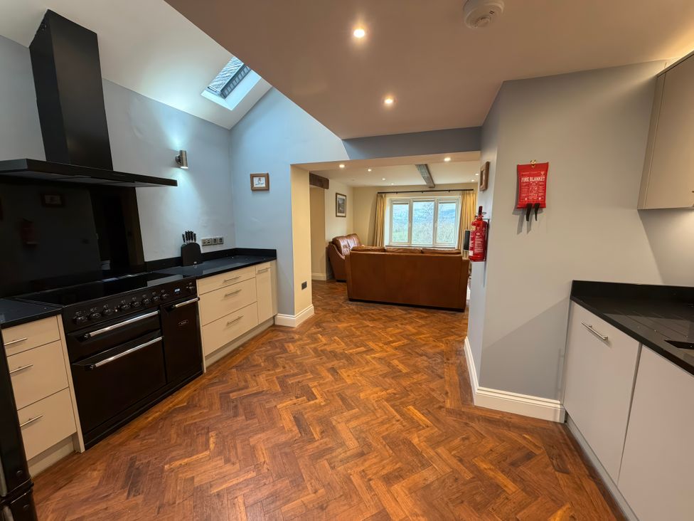 A kitchen with cabinets and an oven at Dancing Beck Cottage in Millbeck