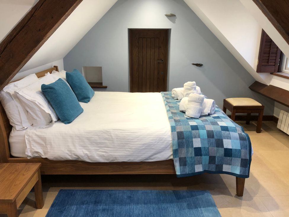 A bedroom with a bed and blue accents at Dancing Beck Cottage in Millbeck